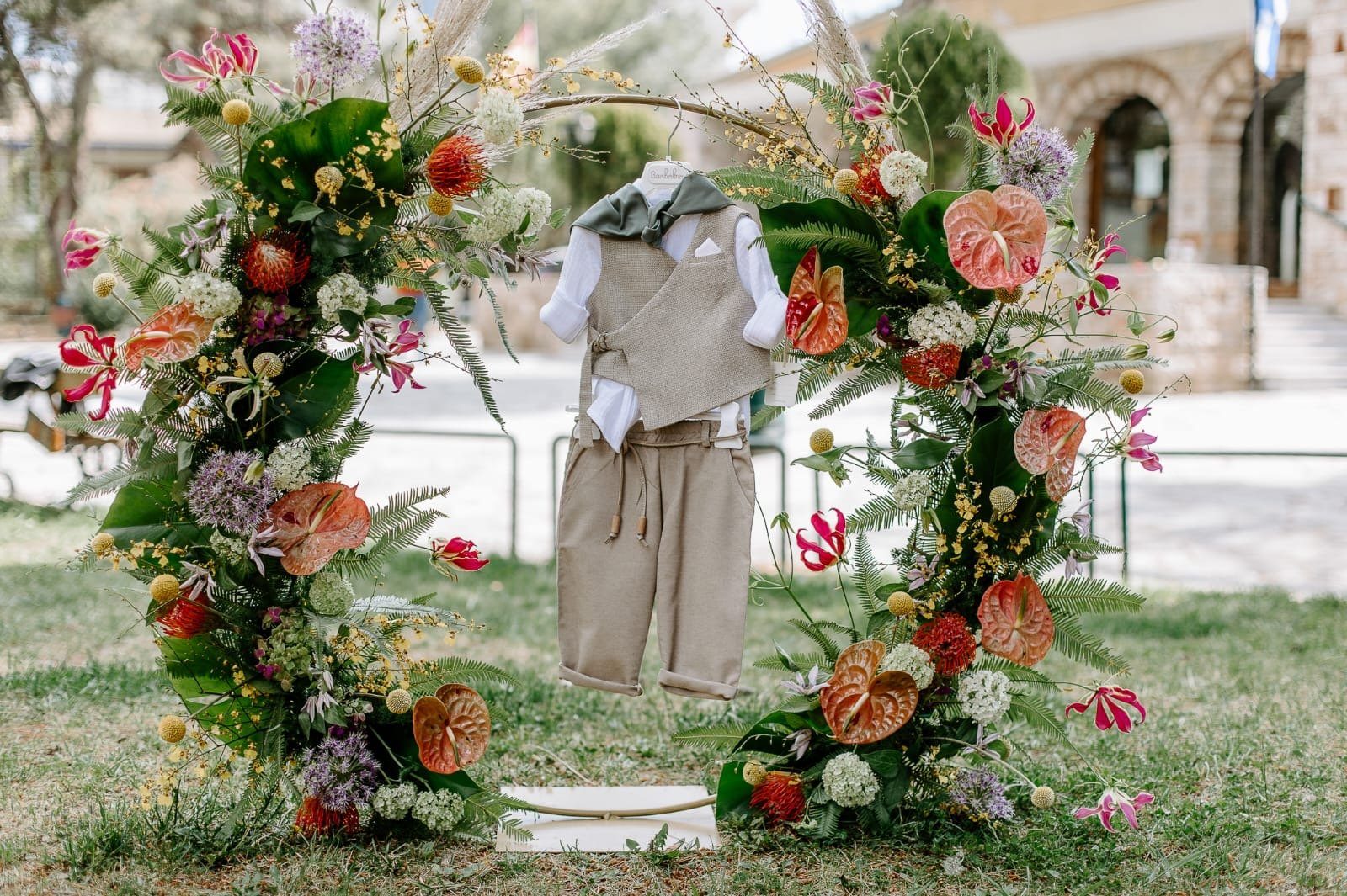 Floral arch and ceremonial clothing prepared for a baptism