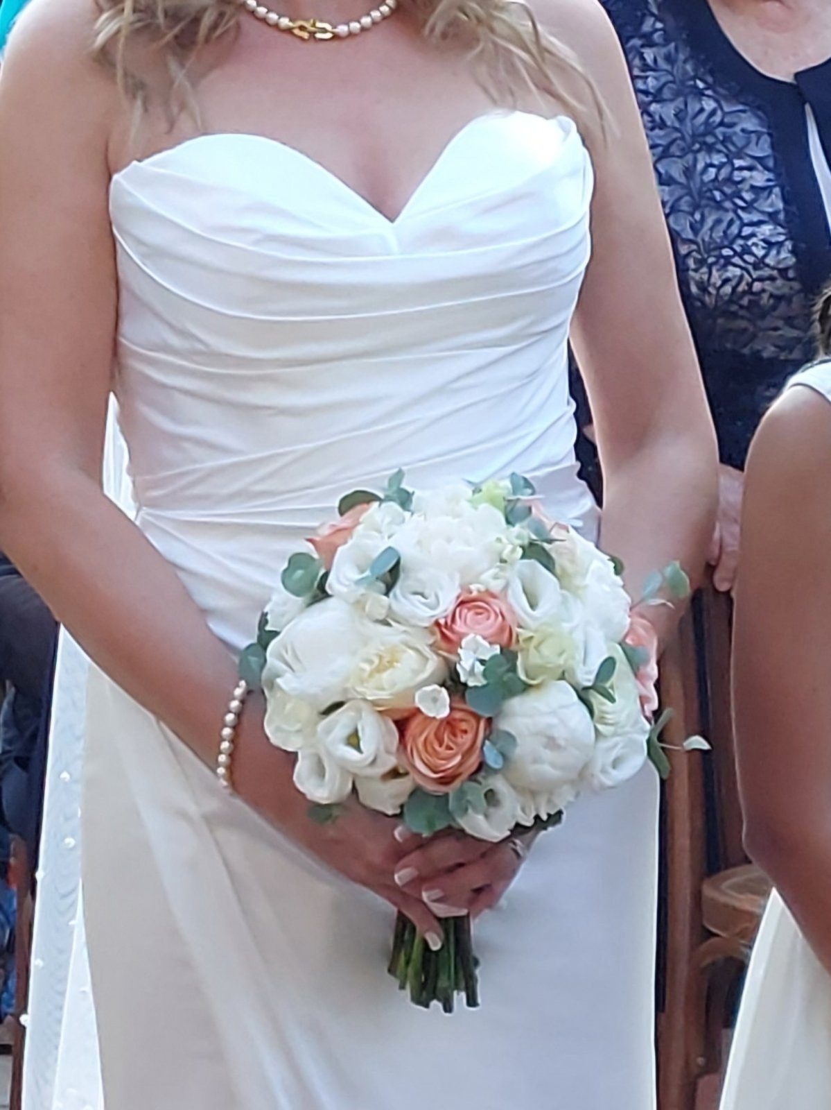 Bride holding a white and peach wedding bouquet