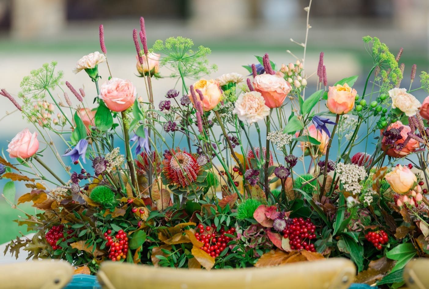 Layered floral arrangements with greenery at an event setting