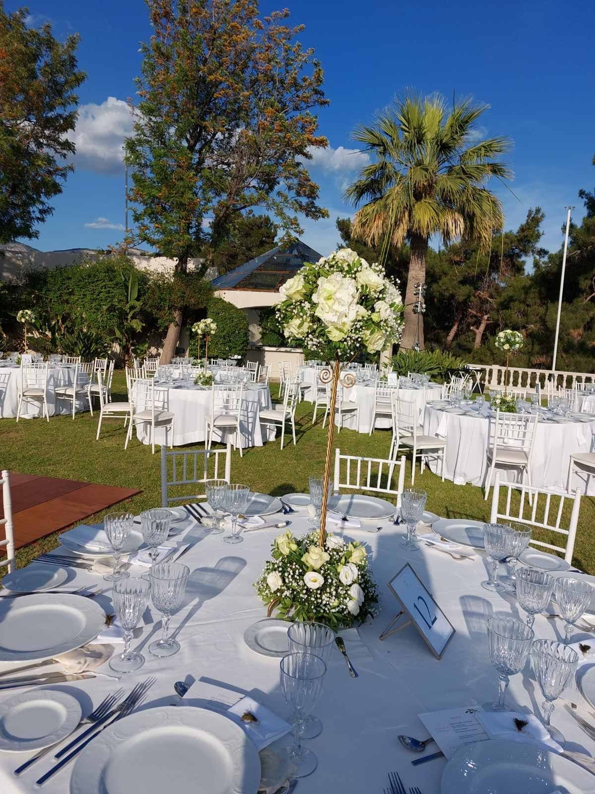 Outdoor wedding aisle framed with abundant floral arrangements