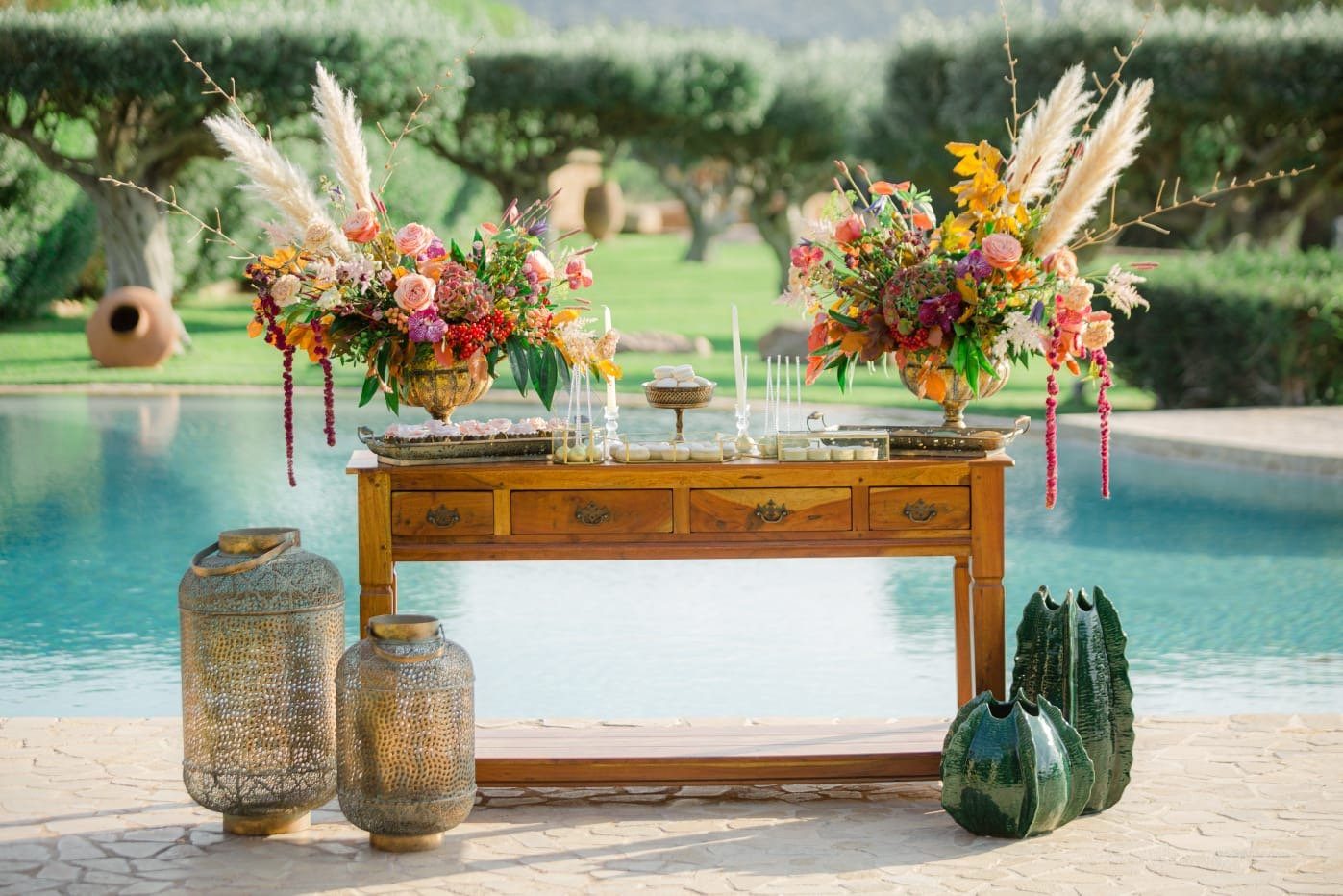Colourful floral installation arranged beside a pool for a wedding celebration