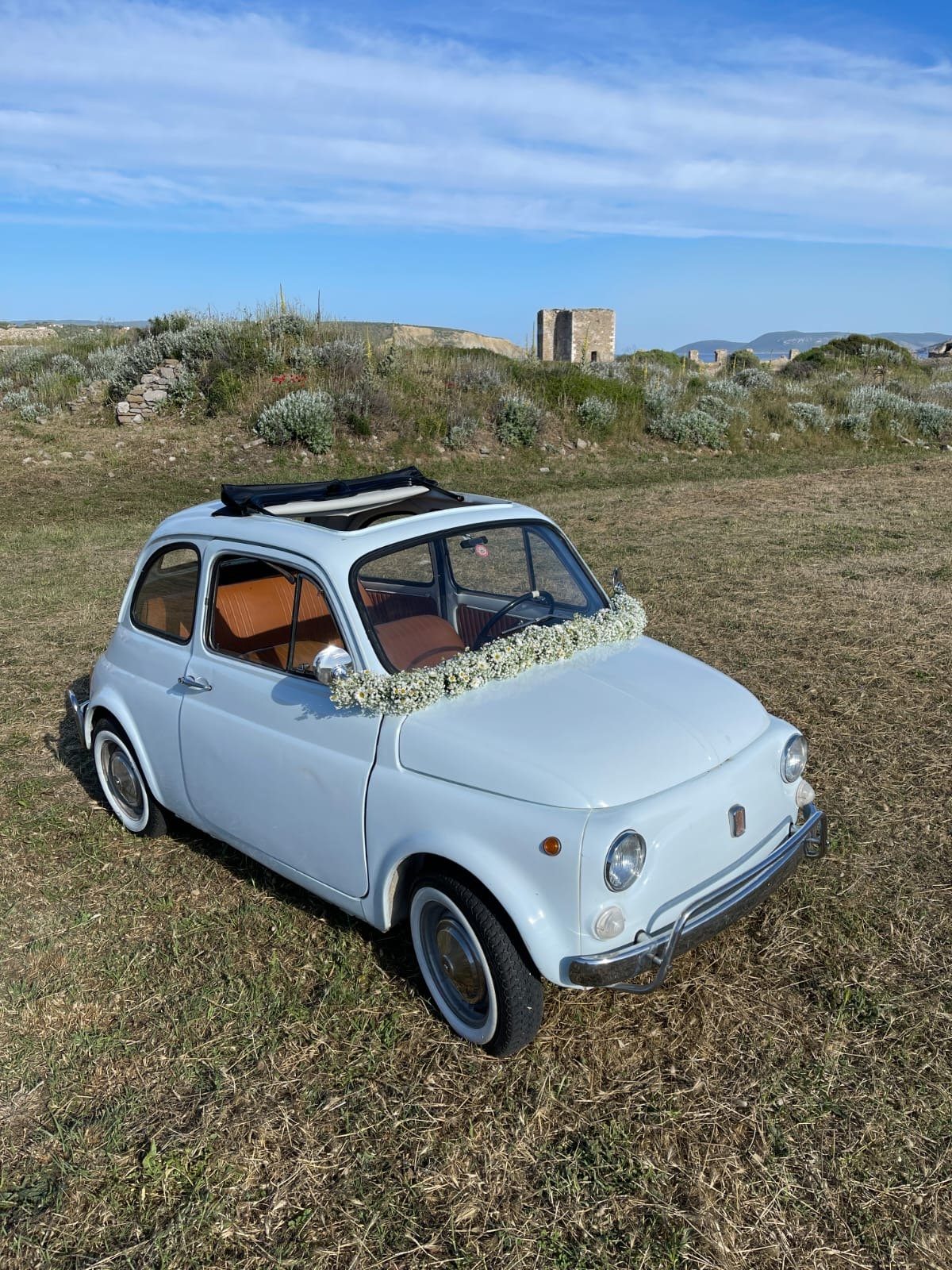 Wedding flowers arranged around a vintage car in Greece